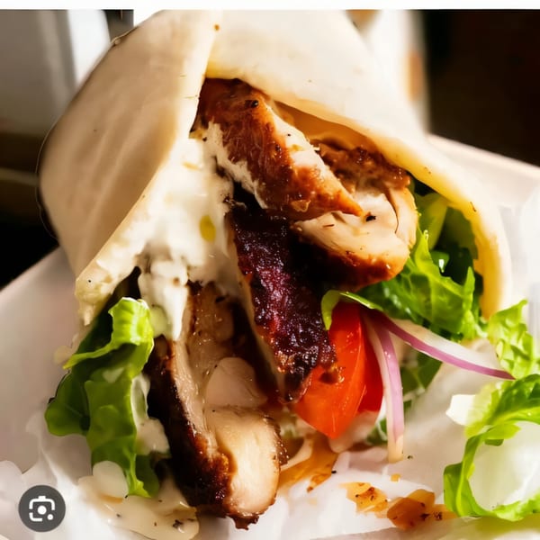 A Killer Kabab chicken kebab wrap, filled with grilled chicken, fresh lettuce, tomatoes, and white sauce.